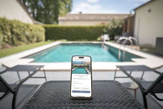 Gana entre 25€ y 90€ la hora alquilando tu piscina: el método Swimmy en unos pocos clics Una piscina privada con smartphone mostrando una reserva de alquiler